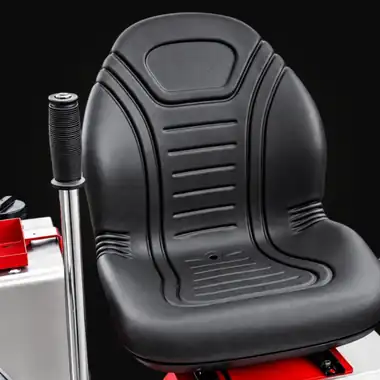 Black Low Rider operator seat beside a rubber-coated control lever