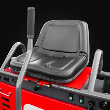 Black operator seat with a control lever above a red housing with a panel