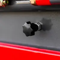 Black multi-arm knob on a grey housing above a red rail